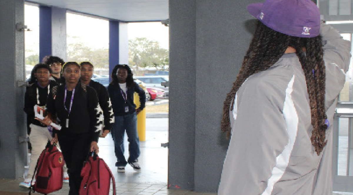 CLOTHES CHECK: Coach Kevon Phillips greets students while making sure they are in dress code. 